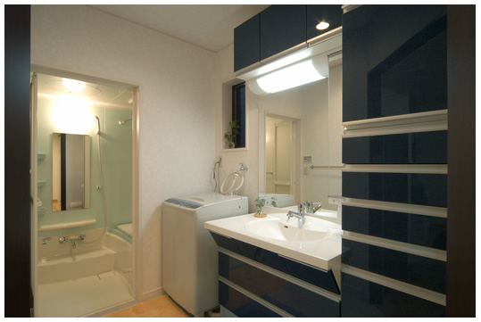 すぐ隣が洗面所になっていて、濃いブルーの洗面台がよく見えるレイアウトになっています。