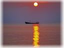 朝焼けに染まる海に一艘の小船